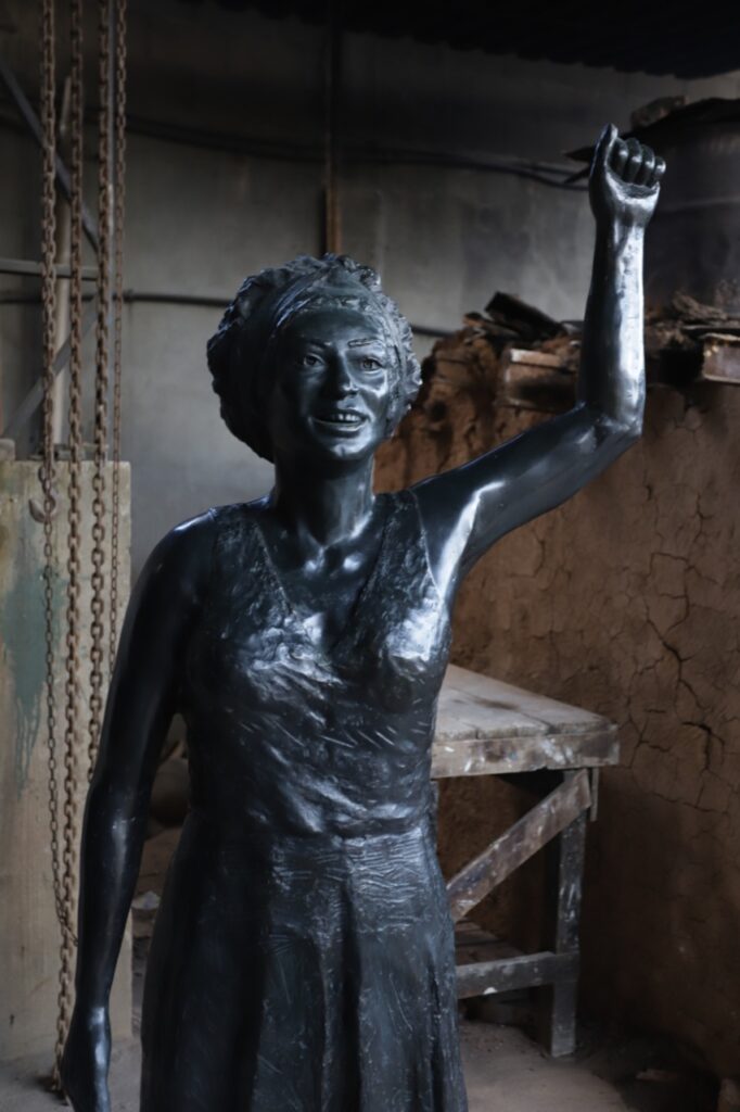 Estatua de bronce de Marielle Franco levantando su brazo derecho.
