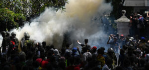 Army personnel use tear gas to disperse demonstrators during an anti-government protest outside the office of Sri Lanka's prime minister in Colombo on July 13, 2022. - Thousands of anti-government protesters stormed into Sri Lanka Prime Minister Ranil Wickremesinghe's office on July 13, hours after he was named as acting president, witnesses said. (Photo by Arun SANKAR / AFP)