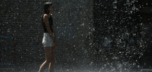 A young girl cools off in the fountains of Square Charles de Gaulle, in Toulouse, southern France, on July 13, 2022. - France suffered soaring temperatures on July 13, 2022, edging closer to the blistering heat already engulfing Spain and Portugal as wildfires destroyed vast stretches of Western European forestland. (Photo by Valentine CHAPUIS / AFP)