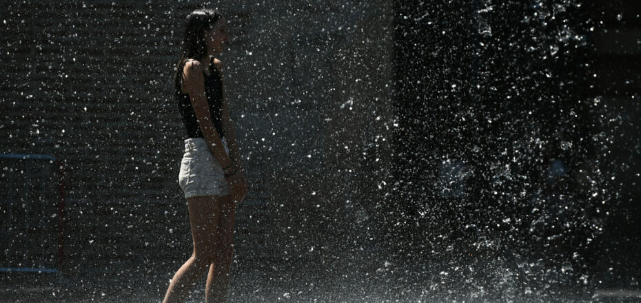 A young girl cools off in the fountains of Square Charles de Gaulle, in Toulouse, southern France, on July 13, 2022. - France suffered soaring temperatures on July 13, 2022, edging closer to the blistering heat already engulfing Spain and Portugal as wildfires destroyed vast stretches of Western European forestland. (Photo by Valentine CHAPUIS / AFP)