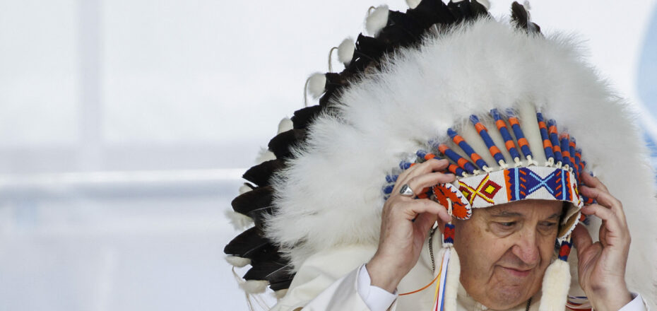 MASKWACIS, AB - JULY 25: Pope Francis wears a traditional headdress that was gifted to him by indigenous leaders during his visit on July 25, 2022 in Maskwacis, Canada. The Pope is touring Canada, meeting with Indigenous communities and community leaders in an effort to reconcile the harmful legacy of the church's role in Canada's residential schools. Cole Burston/Getty Images/AFP (Photo by Cole Burston / GETTY IMAGES NORTH AMERICA / Getty Images via AFP)