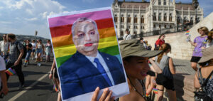A participant holds up a made-up portrait of Hungary's President Viktor Orban during the LGBTIQA+ Pride Parade in Budapest on July 23, 2022, in memory of the Stonewall Riots, the first big uprising of homosexuals against police assaults in New York City on June 27, 1969. (Photo by Ferenc ISZA / AFP)